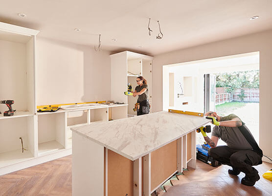 Contractors installing kitchen cabinetry