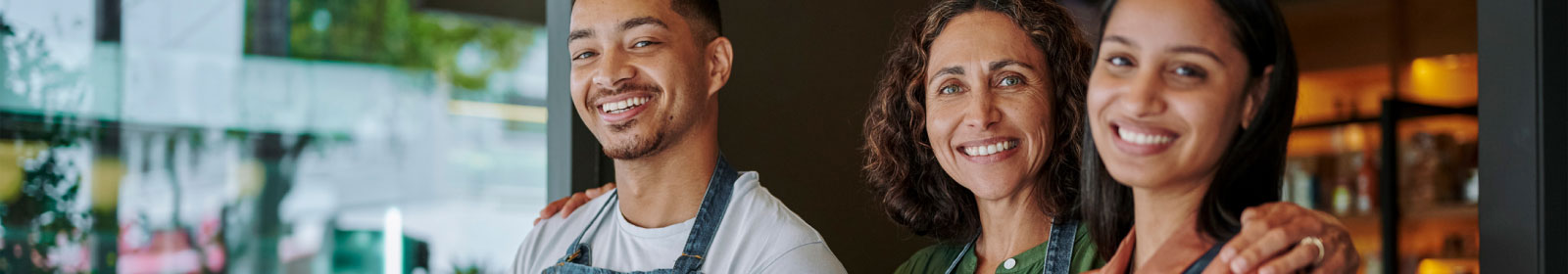 a group of workers in a small shop smiling at the camera