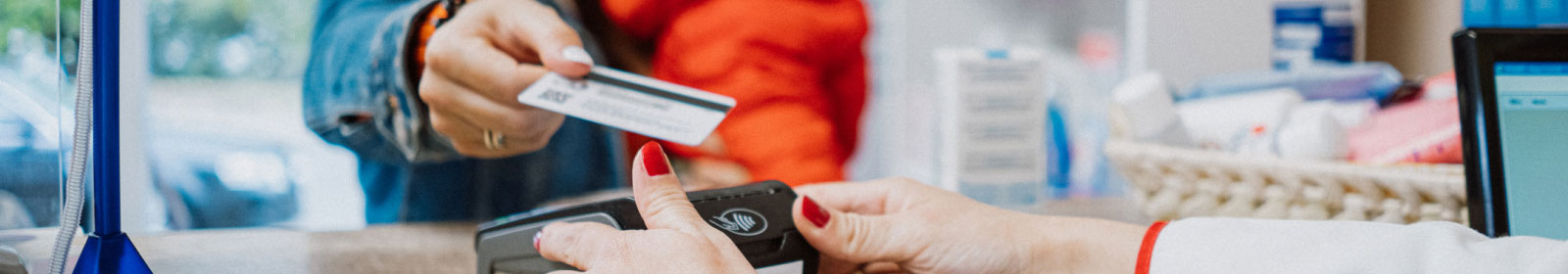 close-up of a person holding a credit card to a payment processor