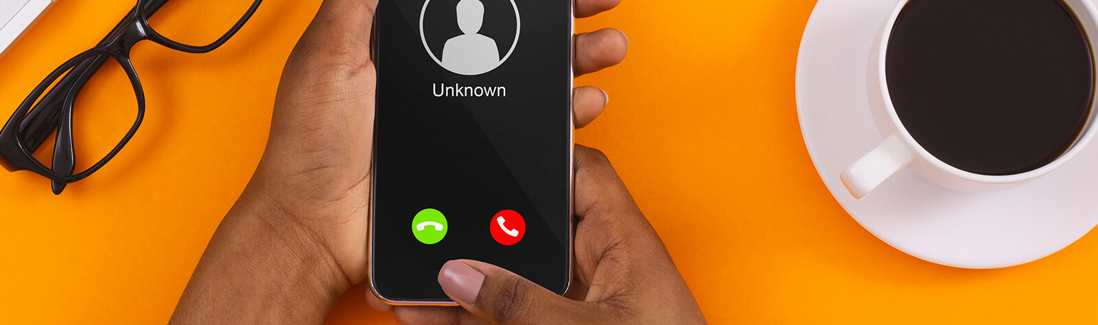 Phone showing unknown caller next to coffee