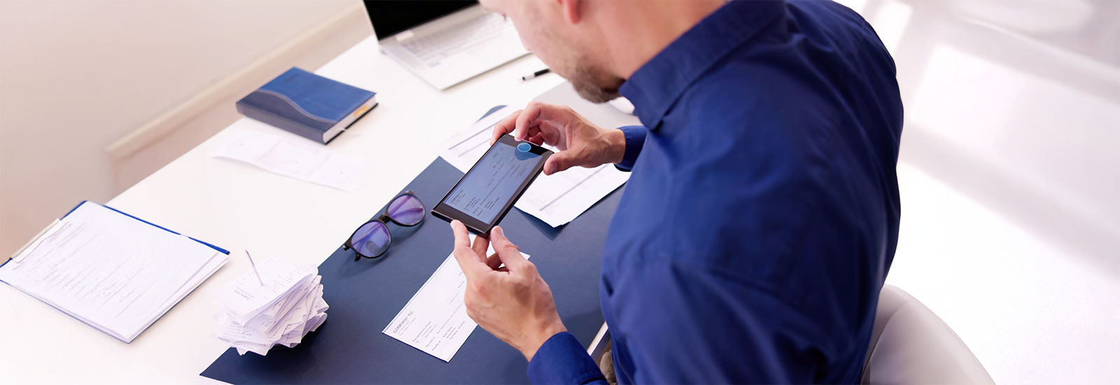 Business Checking, young woman looking at her card and phone